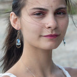 A pair of twisted brass drop earrings featuring blue crystal, amazonite and apatite gemstones