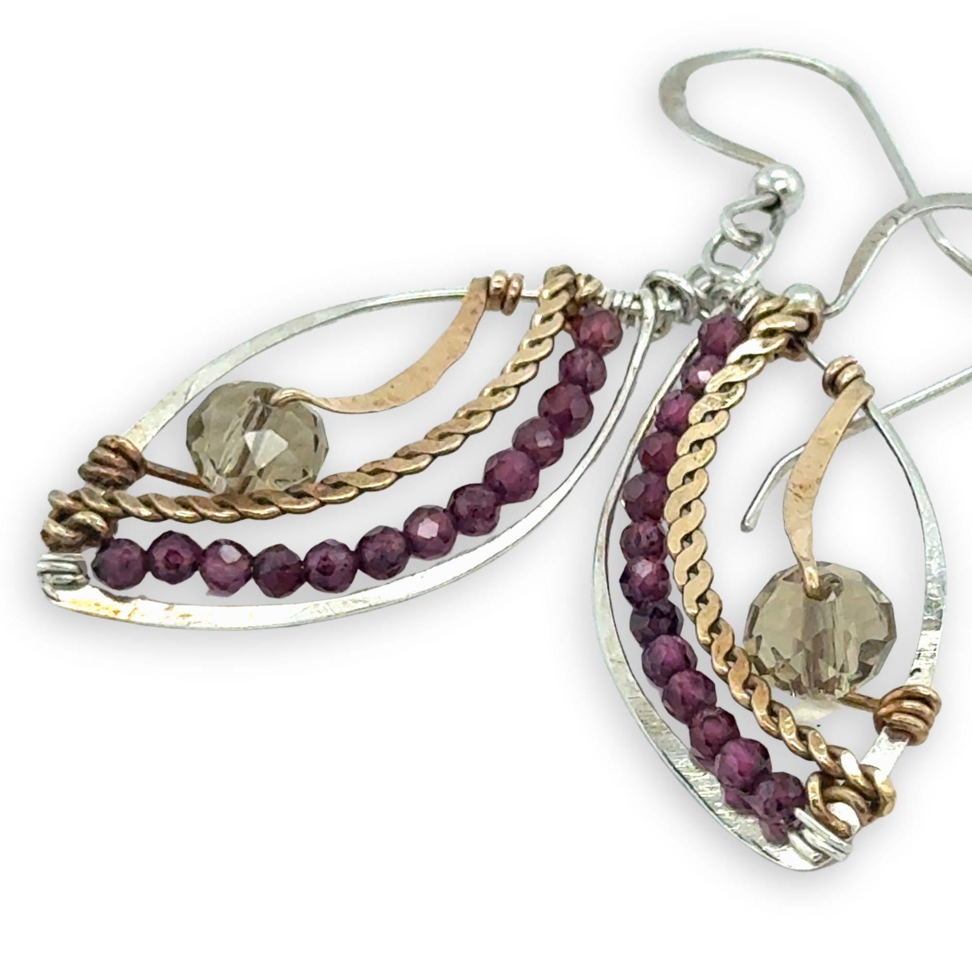 Earrings with gold, silver, and garnet bead details on a white background