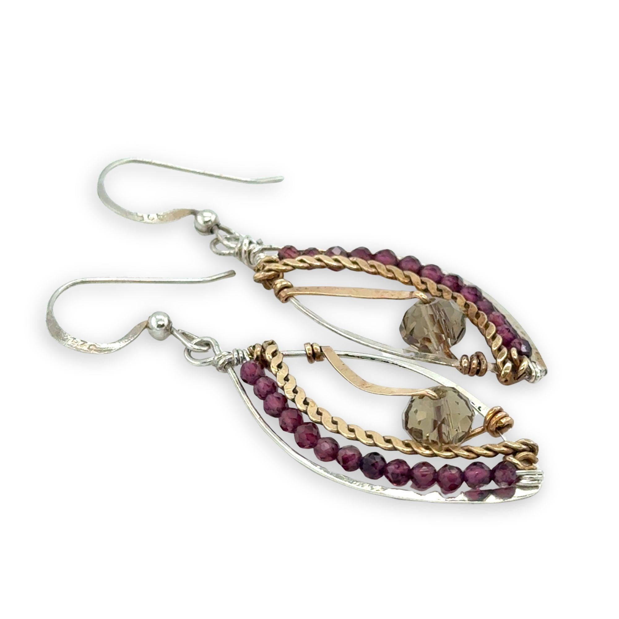 Pair of earrings with gold, silver, and garnet beads on a white background