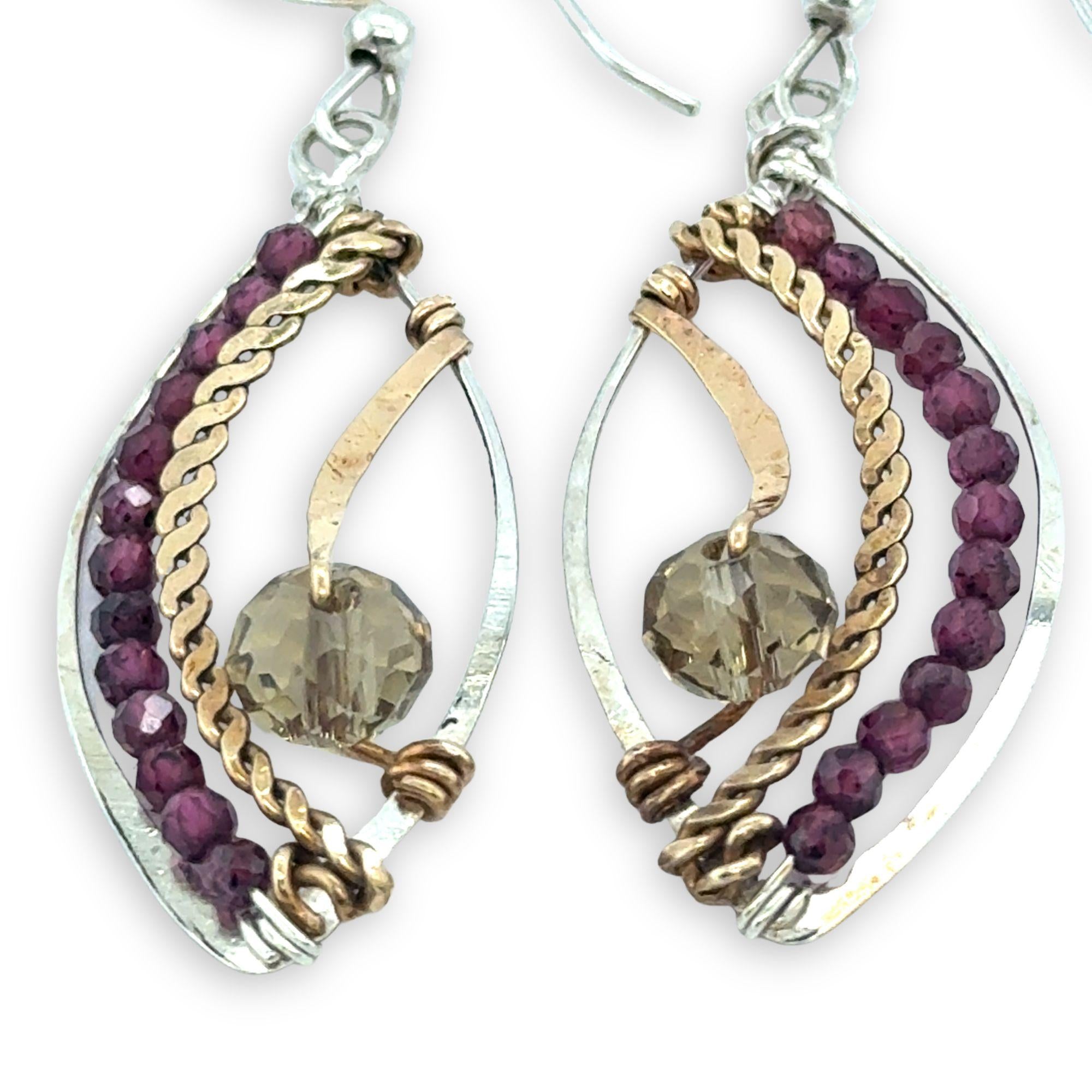 Pair of earrings with garnet beads and gold accents on a white background