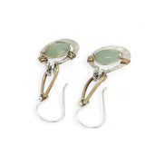 Pair of earrings with green jade gemstones on a white background