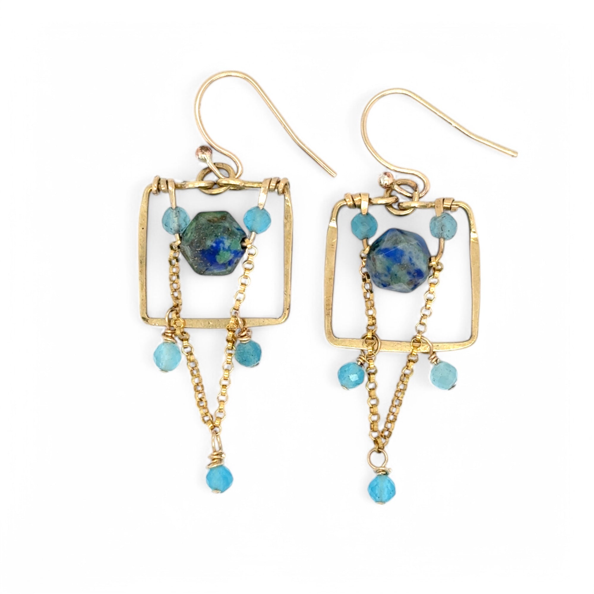 A pair of gold-filled earrings with a geometric puzzle box design, featuring aqua blue cat's eye gemstones and a gold-filled chain.