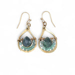 Gold earrings with green agate gemstones on a white background