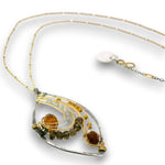 A delicate handmade pendant necklace featuring a hammered silver leaf-shaped frame, gold wire accents, and small gemstone beads in amber, brown, and olive green, shown on a white background.