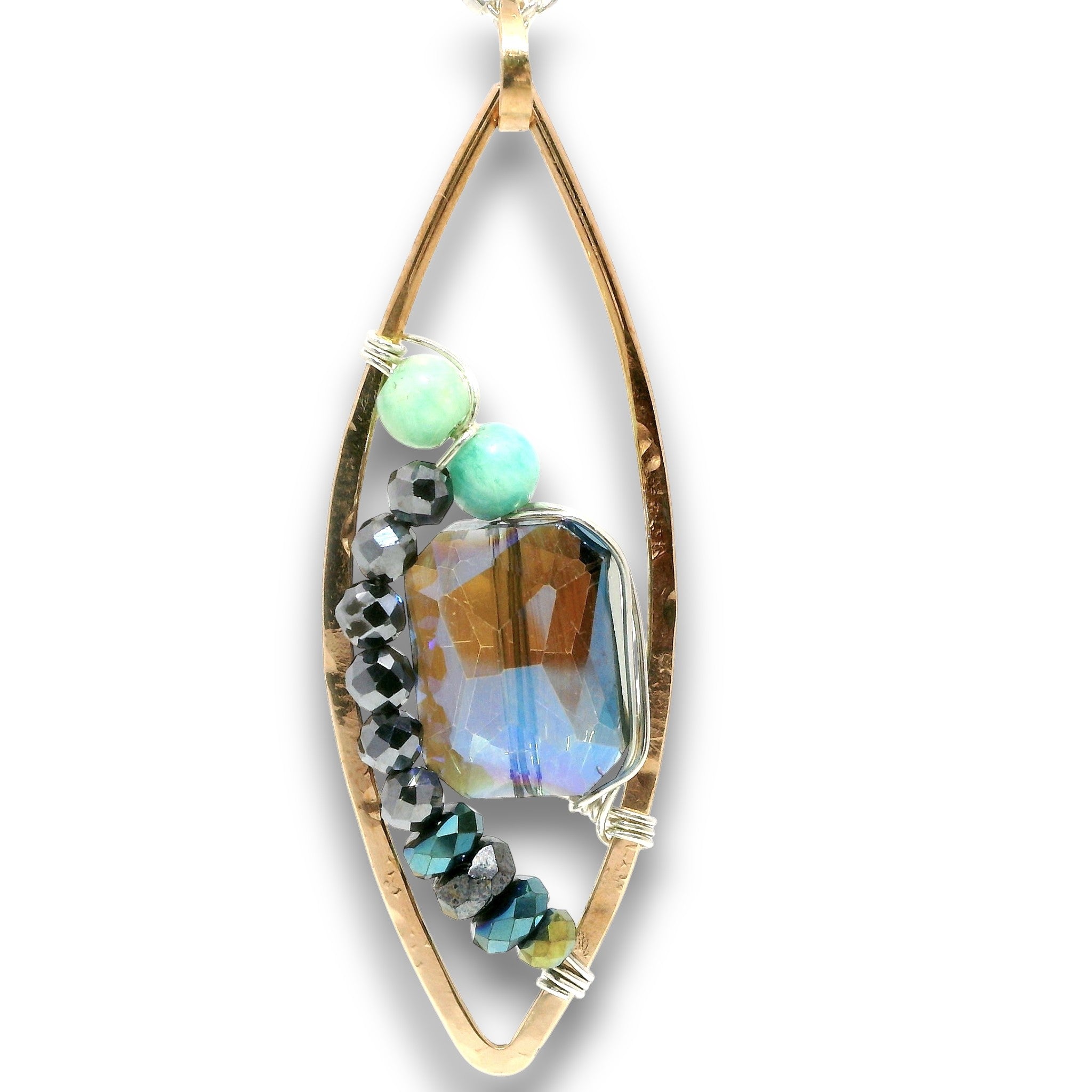 A gold-toned teardrop pendant featuring a large faceted iridescent blue gemstone, accented with light green beads, black faceted beads, and smaller blue-green beads on a white background.
