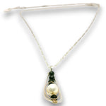 A delicate necklace featuring a large white pearl and dark green beads set in gold-toned metal, suspended from a thin cream-colored chain with an adjustable sliding clasp.