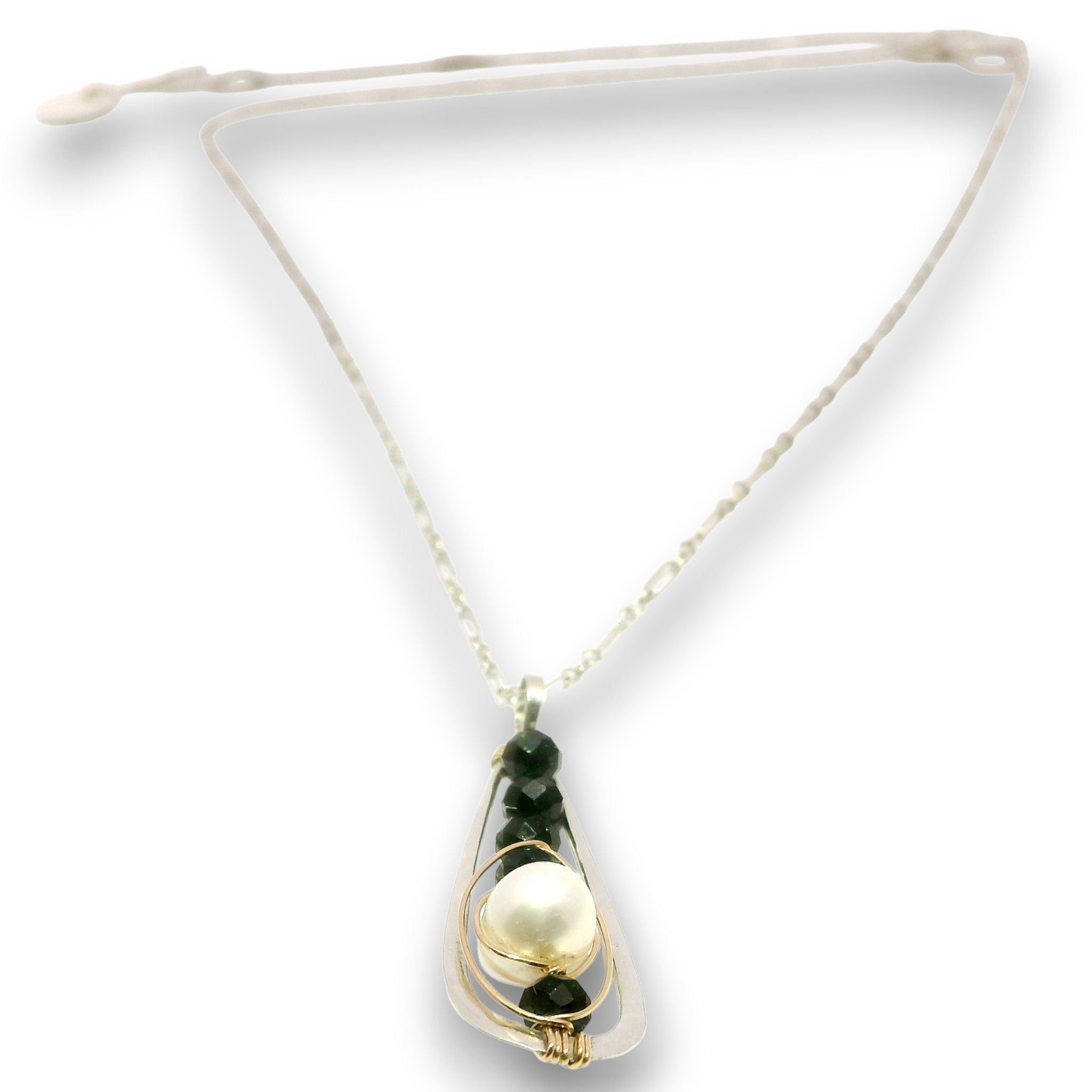 A delicate necklace featuring a large white pearl and dark green beads set in gold-toned metal, suspended from a thin cream-colored chain with an adjustable sliding clasp.