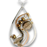 A teardrop-shaped pendant necklace featuring a polished silver-tone frame, curved rose gold-tone bands, brown pearl-like beads, a smoky brown glass bead, and a small clear crystal on a white background.
