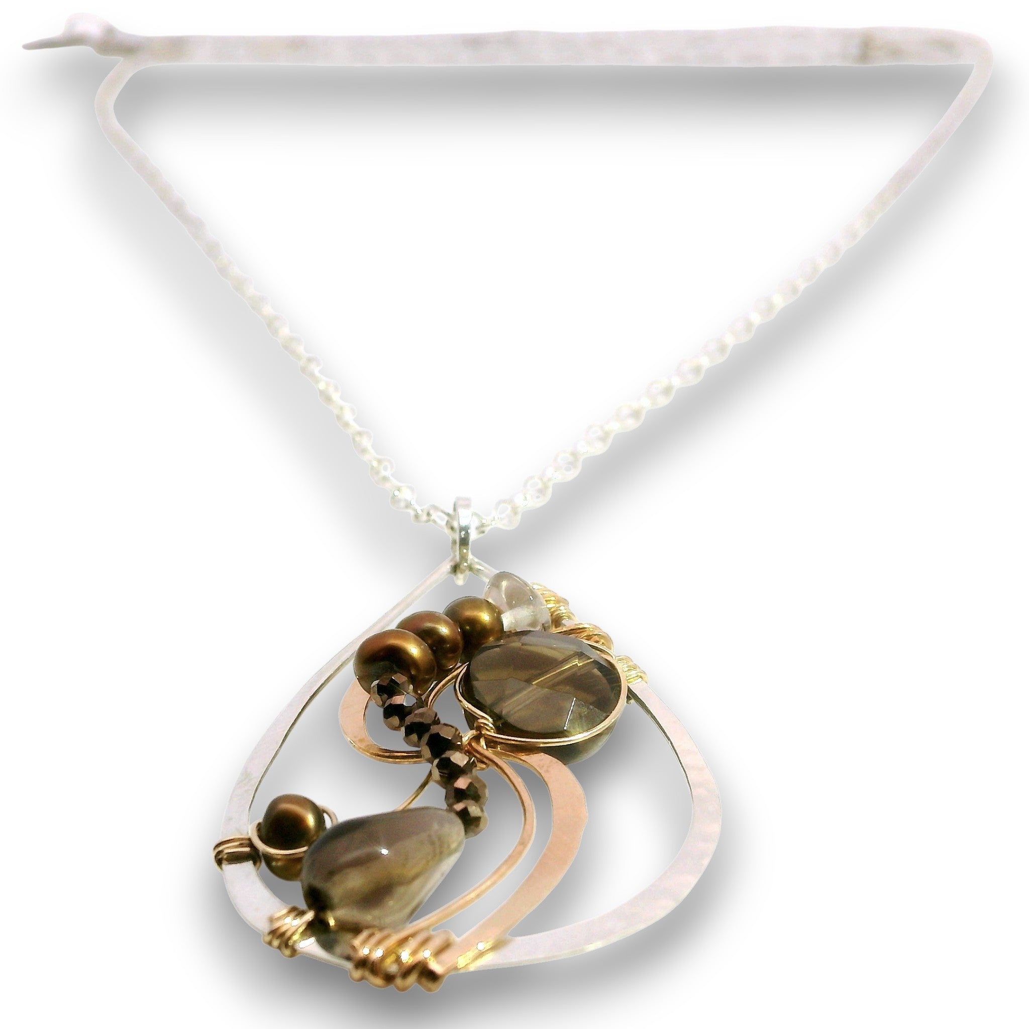 A teardrop-shaped pendant necklace featuring a white mother-of-pearl frame, a large smoky brown teardrop gemstone, a smaller round smoky brown stone, and bronze beads, suspended from a delicate white chain.