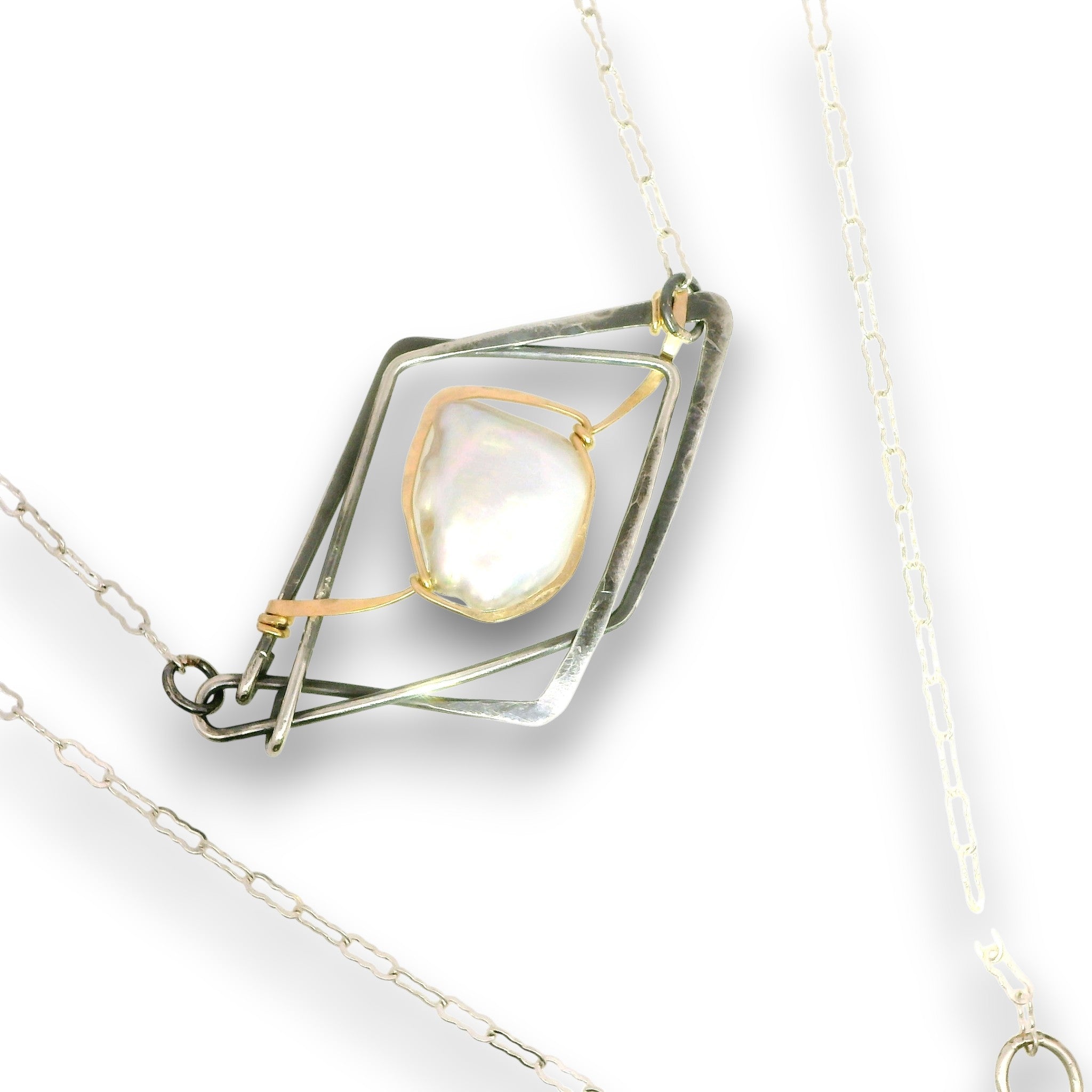 A silver and gold geometric pendant necklace featuring a central iridescent white stone, displayed on a clean white background.