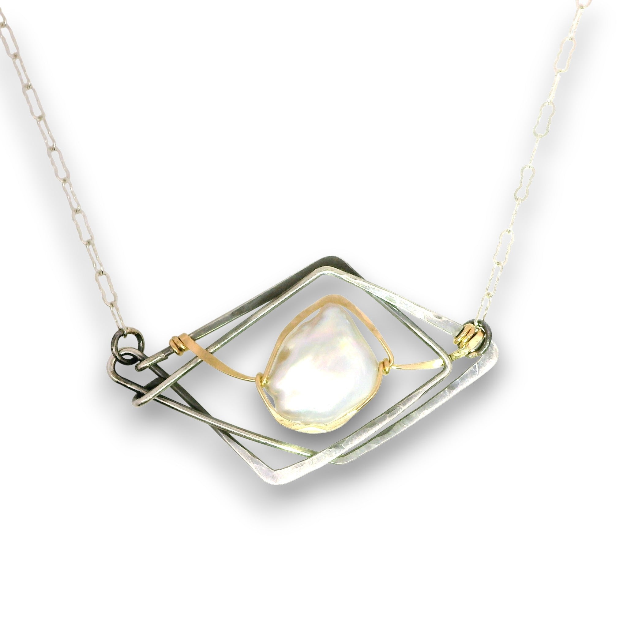 A silver-toned geometric pendant necklace featuring a central teardrop-shaped iridescent white pearl held by gold-toned wire within a layered diamond frame, suspended from a silver link chain.