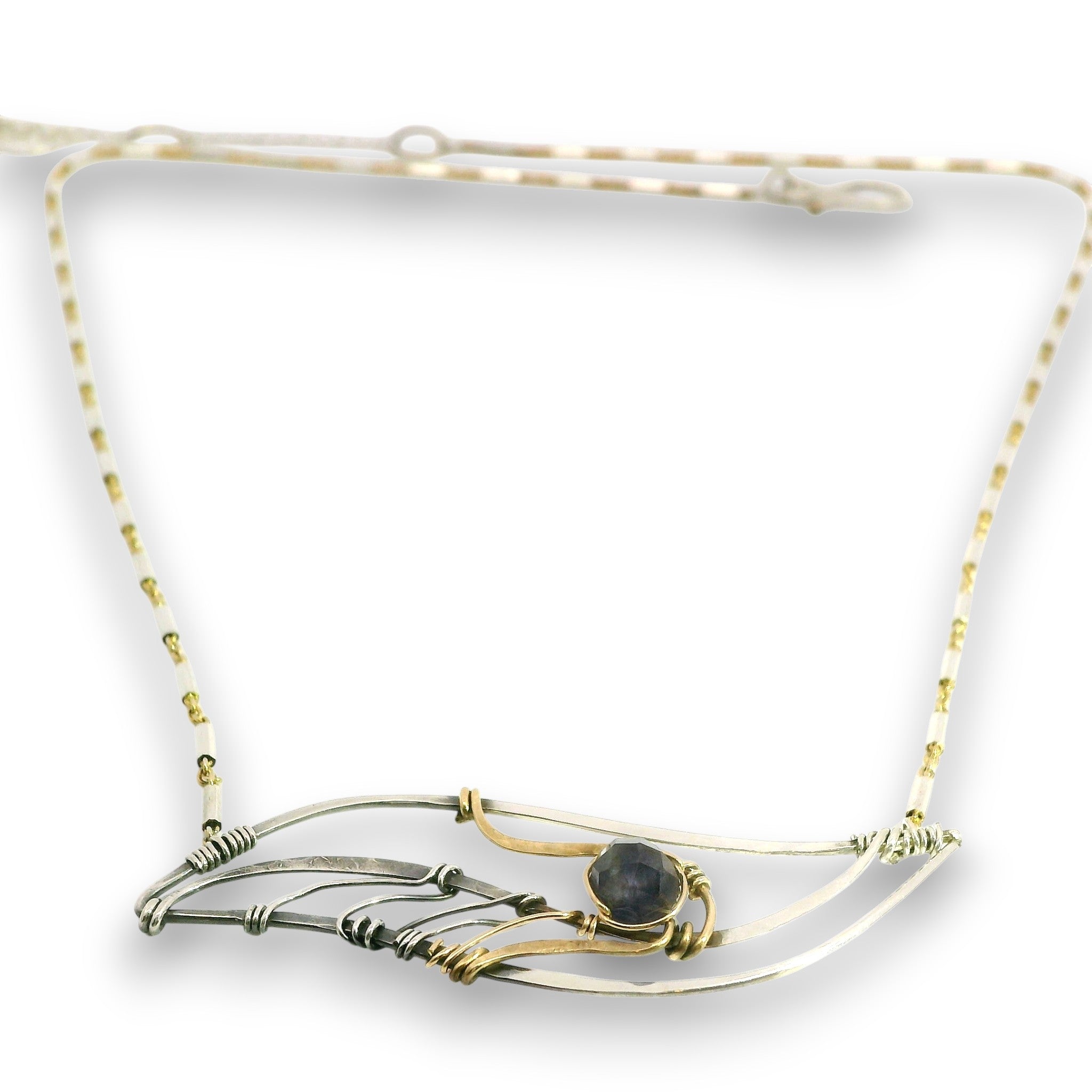 A delicate wire-wrapped necklace featuring a central dark gray stone, crafted with both silver and gold-toned metal wires on a white background.