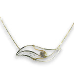 A delicate necklace featuring a wave-like pendant made of textured silver and gold wire, with a small round gray stone in the center, set against a plain white background.