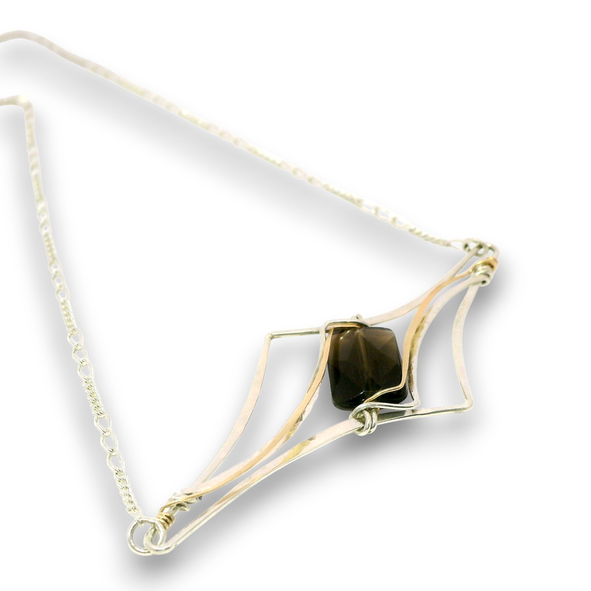 A delicate necklace featuring a central dark brown tiger's eye stone wrapped in gold-toned metal, suspended from a fine silver-toned chain on a white background.