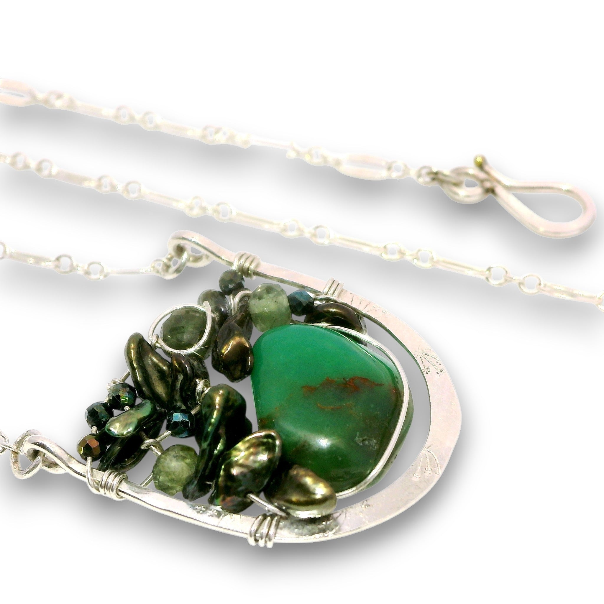A silver wire-wrapped necklace featuring a large green stone pendant and smaller dark green and metallic green beads, shown on a white background.