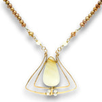 A gold-toned necklace featuring a teardrop-shaped pale cream stone pendant, accented with small white beads and a strand of brownish pearl-like beads on a white background.