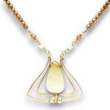A gold-toned necklace featuring a teardrop-shaped pale cream stone pendant, accented with small white beads and a strand of brownish pearl-like beads on a white background.