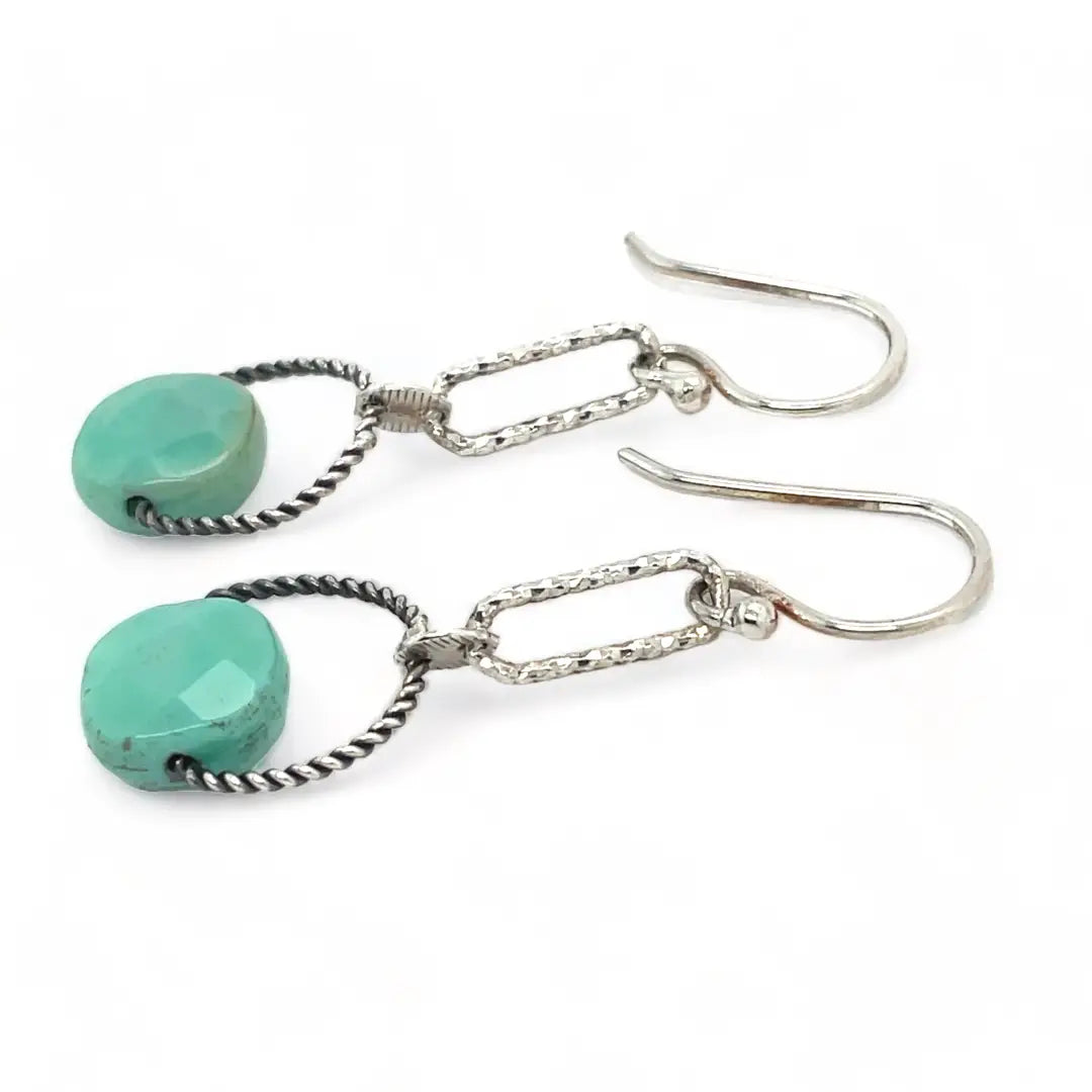 A pair of earrings featuring green chrysoprase stones on sterling silver hooks and twisted rings.