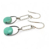 A pair of earrings featuring green chrysoprase stones on sterling silver hooks and twisted rings.