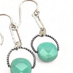 A pair of earrings featuring green chrysoprase stones on sterling silver hooks and twisted rings.