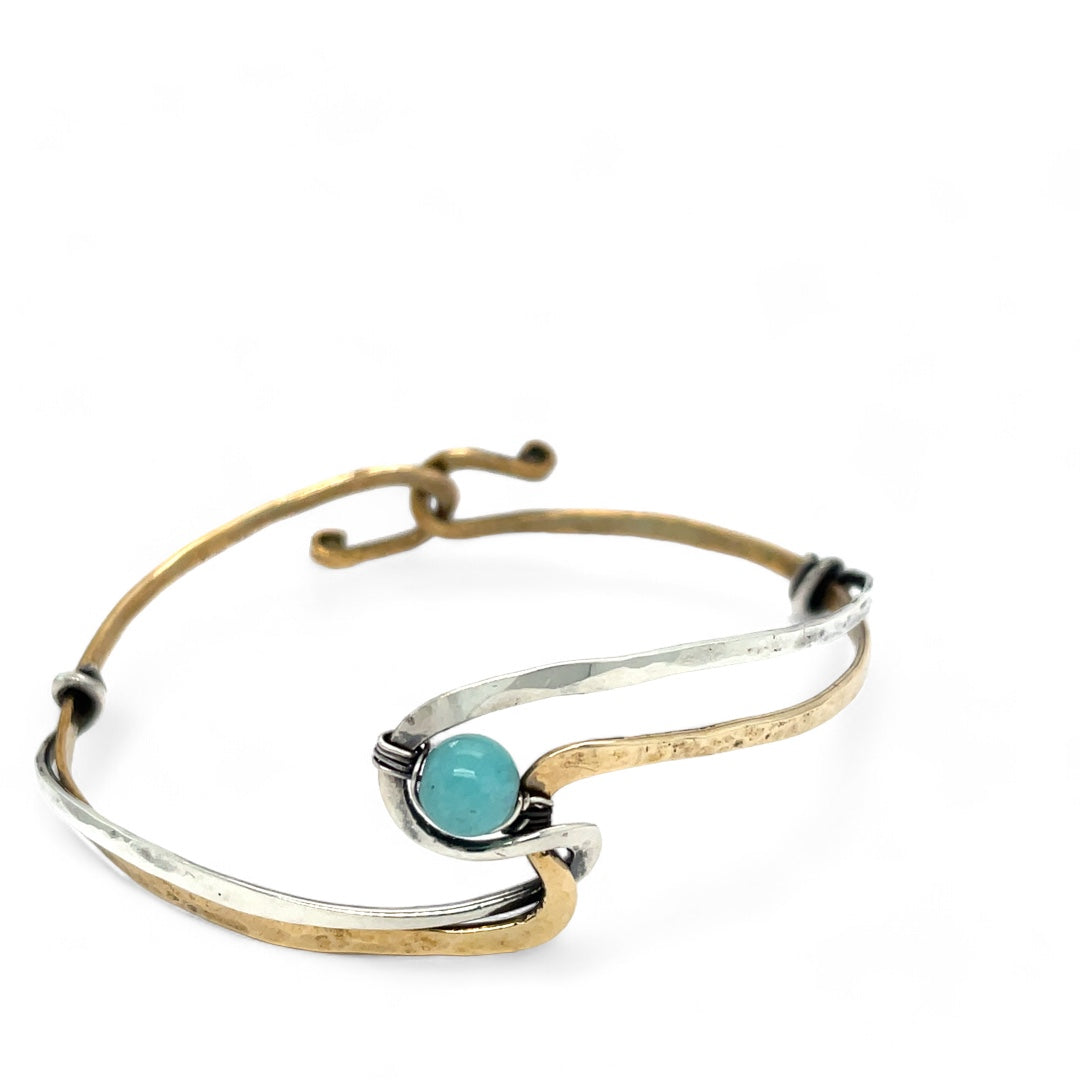 A sterling silver and brass hammered cuff bracelet featuring a single blue amazonite gemstone, with a twist design and an interlocked structure.