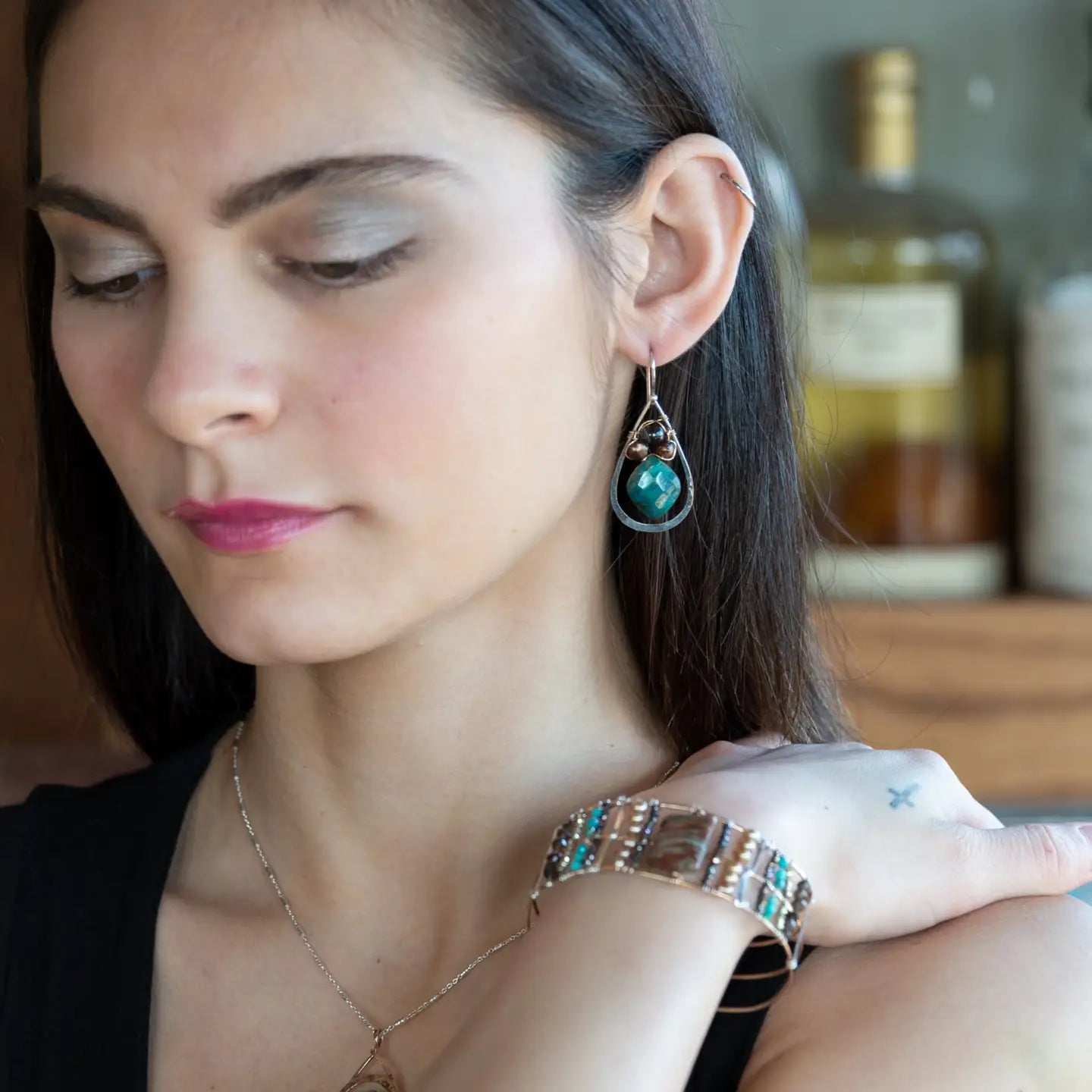 A pair of sterling silver drop earrings with gold filled wire, featuring chrysocolla drop gemstones, chocolate freshwater pearls, and chocolate striped agate.