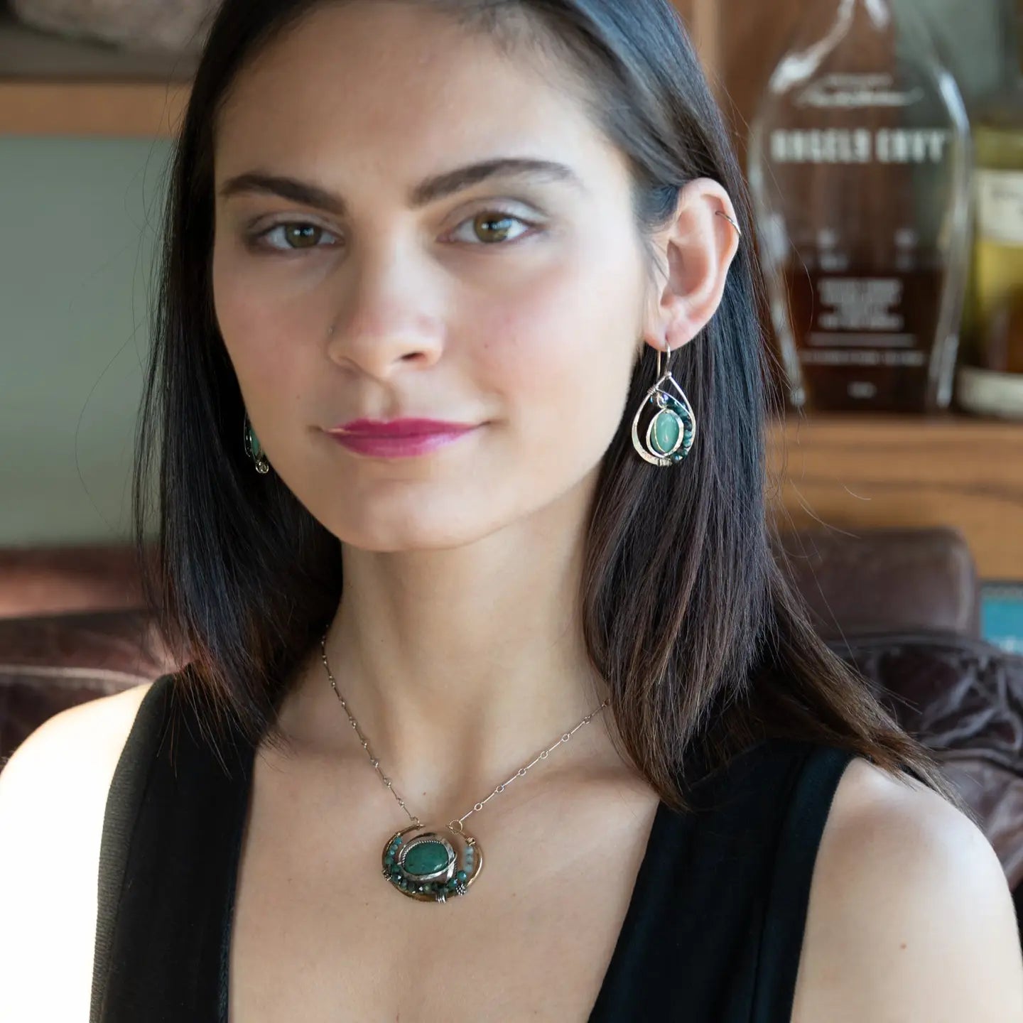  brass cup necklace with smooth african opal jasper oval wrapped in hammered sterling silver, oxidized sterling twist, emerald gemstones, and crystal