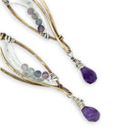 Faceted amethyst drops hang from a brass marquise earring with hammered sterling silver arches and faceted fluorite gemstones