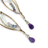 Faceted amethyst drops hang from a brass marquise earring with hammered sterling silver arches and faceted fluorite gemstones