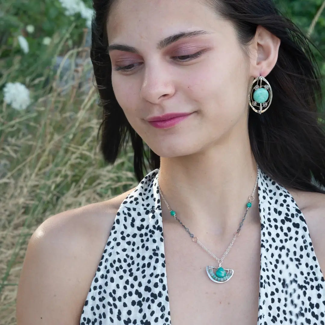 A sterling silver and amazonite gemstone necklace featuring a faceted dark amazonite drop on a sterling silver anchor shaped pendant and an oxidized textured chain with additional gemstones.