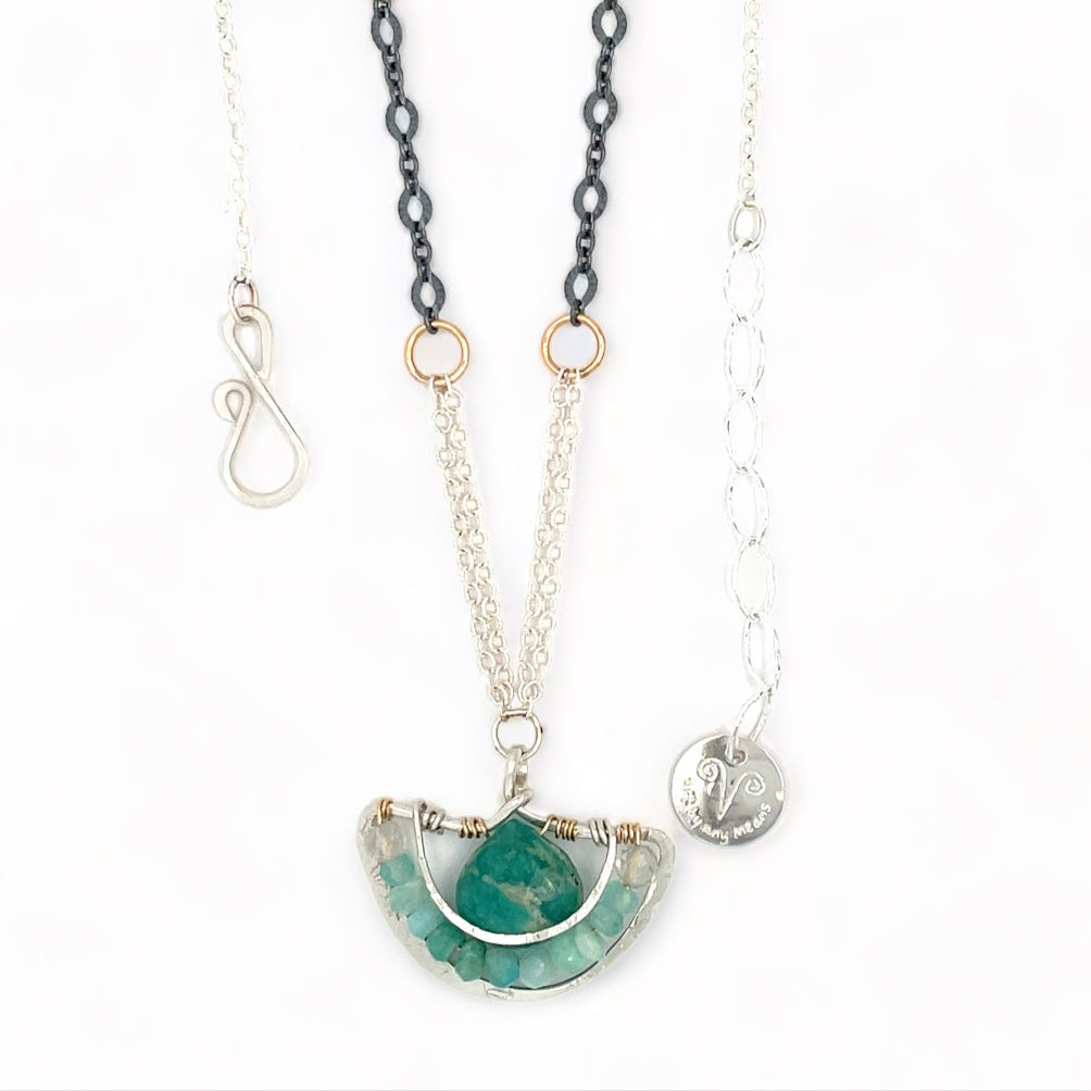 A sterling silver and amazonite gemstone necklace featuring a faceted dark amazonite drop on a sterling silver anchor shaped pendant and an oxidized textured chain with additional gemstones.