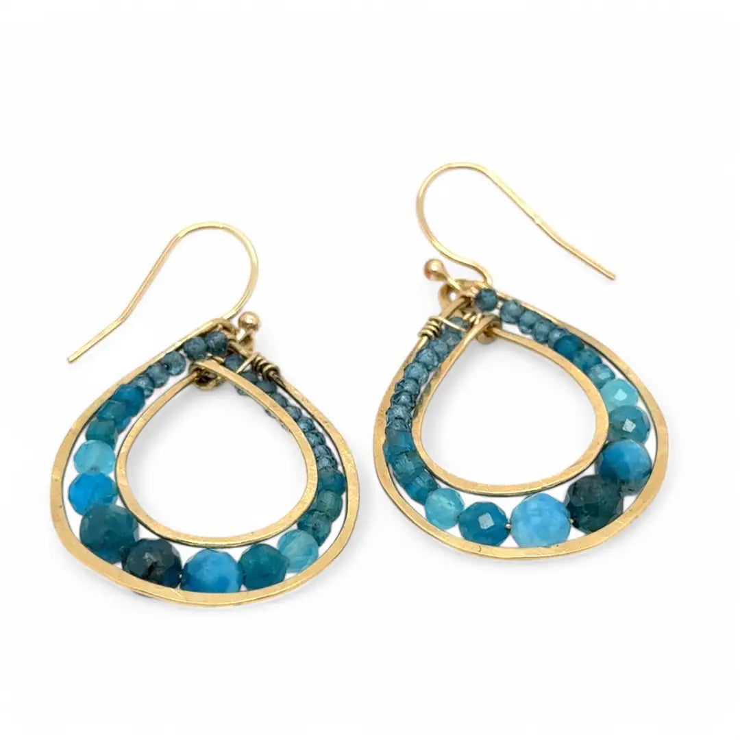 A pair of brass channel hoop earrings with blue apatite gemstones, featuring gold-filled French hooks.