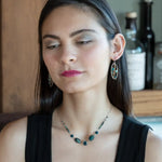 A garden of apatite and chrysocolla gemstones held in veins of gold filled wire attached to a mini handmade sterling silver oval earring with bronze swish accent