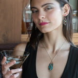 A garden of apatite and chrysocolla gemstones held in veins of gold filled wire attached to a mini handmade sterling silver oval earring with bronze swish accent