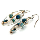 A garden of apatite and chrysocolla gemstones held in veins of gold filled wire attached to a mini handmade sterling silver oval earring with bronze swish accent