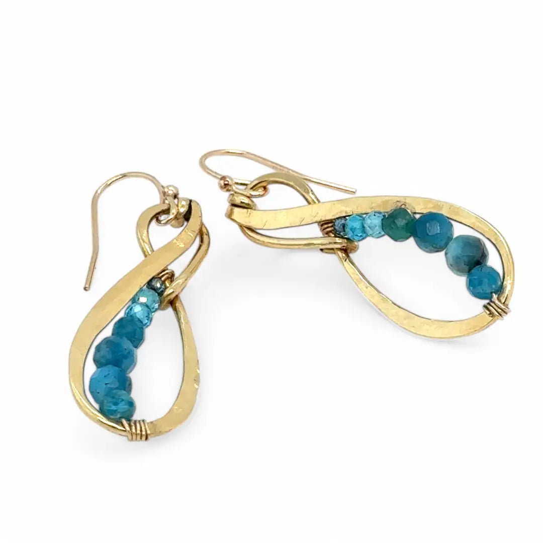 A pair of hammered brass infinity earrings with blue apatite and opal faceted gemstones on gold filled wire
