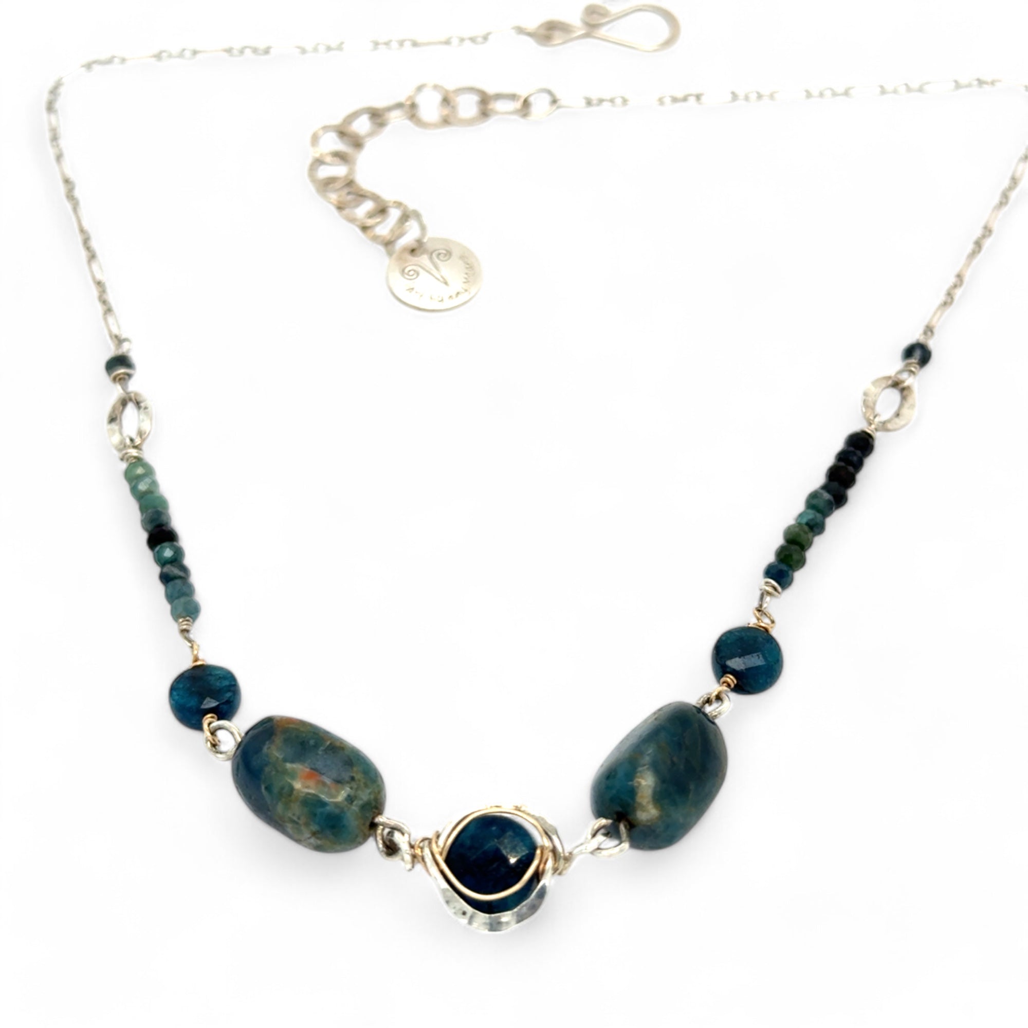 A sterling silver necklace with a chain link design, featuring blue tourmaline micro faceted gemstones and apatite gemstones