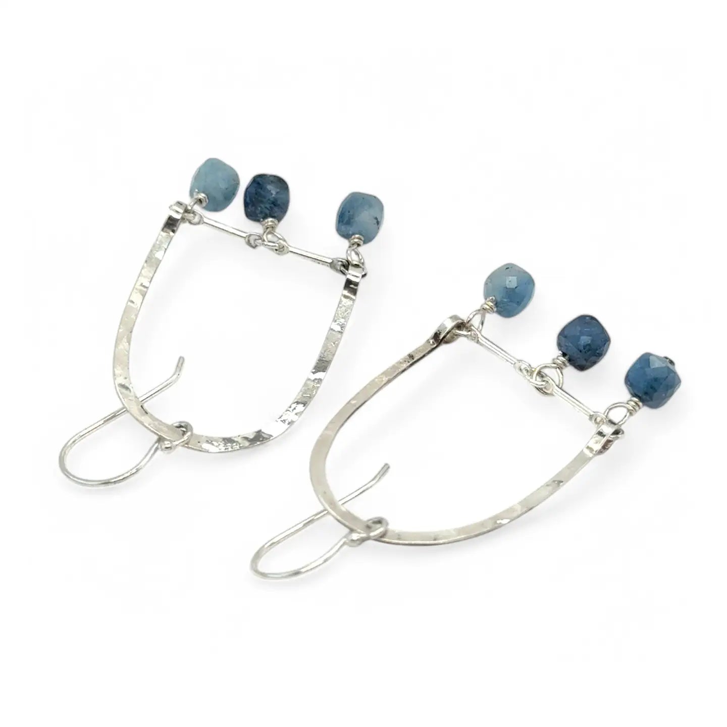 A pair of sterling silver arch earrings with faceted aquamarine gemstones attached to the bottom
