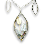 Charm necklace with bronze, sterling silver, and darkened sterling braided petal shapes, accompanied by opal, a carved aquamarine flower, apatite, and crystal gemstones