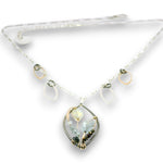 Charm necklace with bronze, sterling silver, and darkened sterling braided petal shapes, accompanied by opal, a carved aquamarine flower, apatite, and crystal gemstones