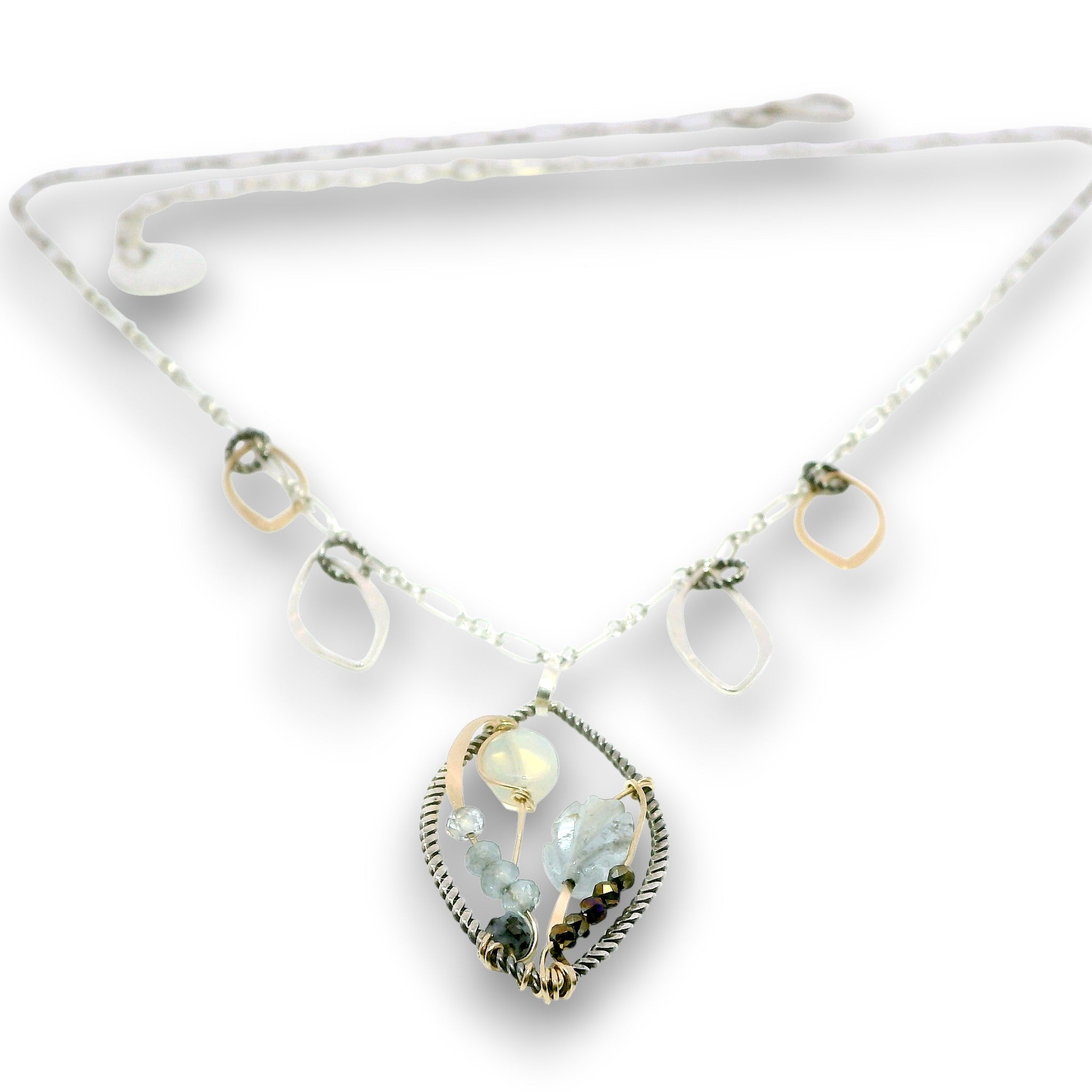 Charm necklace with bronze, sterling silver, and darkened sterling braided petal shapes, accompanied by opal, a carved aquamarine flower, apatite, and crystal gemstones