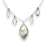 Charm necklace with bronze, sterling silver, and darkened sterling braided petal shapes, accompanied by opal, a carved aquamarine flower, apatite, and crystal gemstones