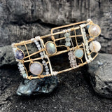 Wide bronze double cuff with sterling silver hammered bars decorated in a plaid pattern with aquamarine, moonstone, labradorite, apatite, and iolite gemstones