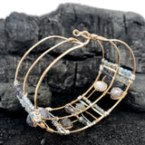 Wide bronze double cuff with sterling silver hammered bars decorated in a plaid pattern with aquamarine, moonstone, labradorite, apatite, and iolite gemstones
