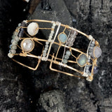 Wide bronze double cuff with sterling silver hammered bars decorated in a plaid pattern with aquamarine, moonstone, labradorite, apatite, and iolite gemstones