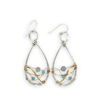 Aquamarine faceted gemstones weaved in gold filled wire along side brass hammered wire on a handmade sterling silver infinity shaped earrings