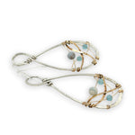 Aquamarine faceted gemstones weaved in gold filled wire along side brass hammered wire on a handmade sterling silver infinity shaped earrings