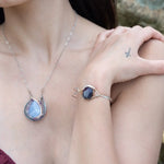 Sterling silver cuff bracelet with a large faceted dark purple amethyst gemstone nugget wrapped in bronze wire