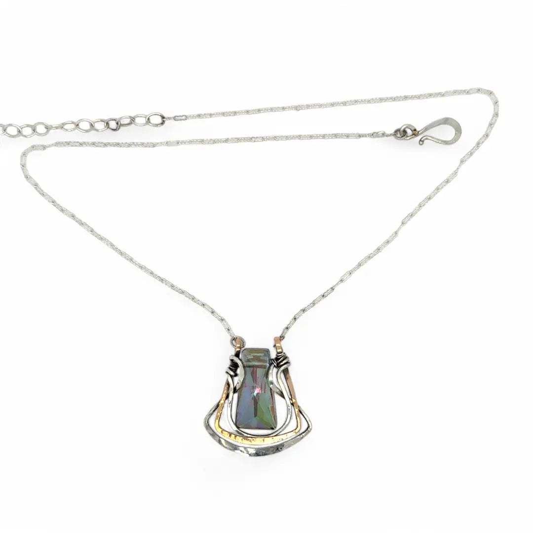A blue/purple rectangular crystal is held in layers of sterling silver and bronze hammered wire pendant on sterling silver delicate chain necklace
