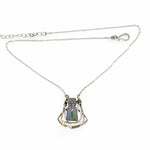 A blue/purple rectangular crystal is held in layers of sterling silver and bronze hammered wire pendant on sterling silver delicate chain necklace